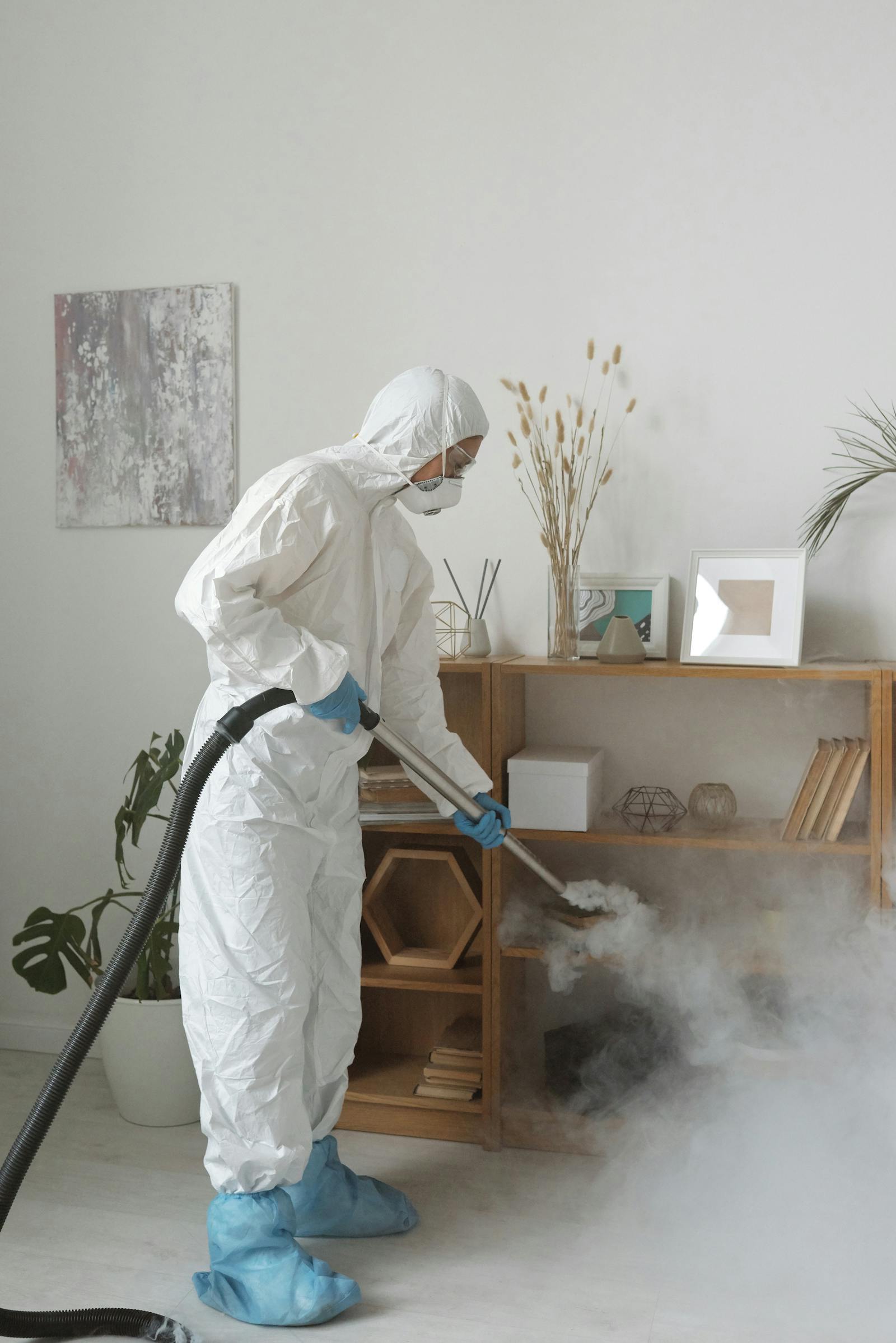 Protective-suit cleaner disinfecting a room